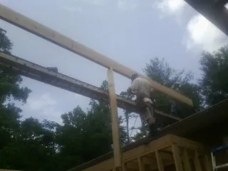 Carpenter setting a ridge beam over a new addition frame — Ice Dam Removal by Roofing Brothers in Leonia