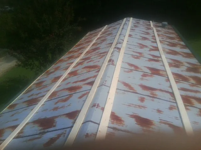 Rusted metal roof panels with new wood purlins before replacement — Storm Damage Roof Repair in Leonia by Roofing Brothers