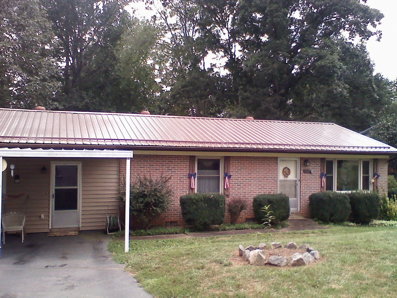 Bronze metal roof and carport on a brick ranch home — Roof Repair work by our crew in Leonia